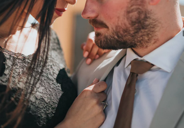 男性のネクタイを握る女性